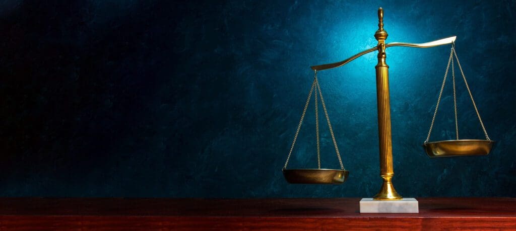 Law scales against textured blue wall